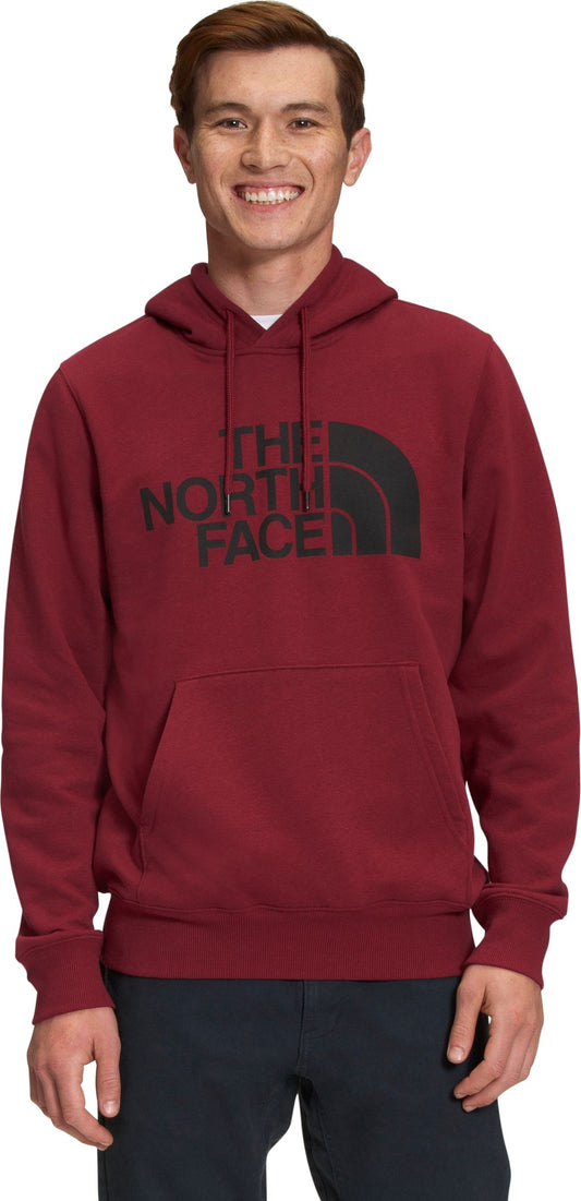 A man wearing a maroon hoodie with a black logo on the chest.
