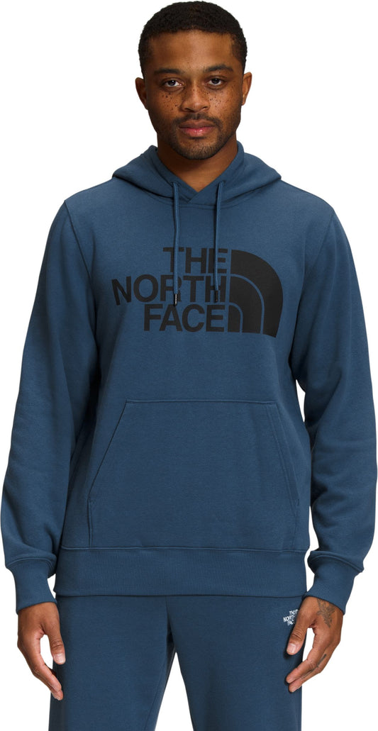 A man wears a blue hooded sweatshirt with a kangaroo pocket and "THE NORTH FACE" printed on the chest in large black letters.