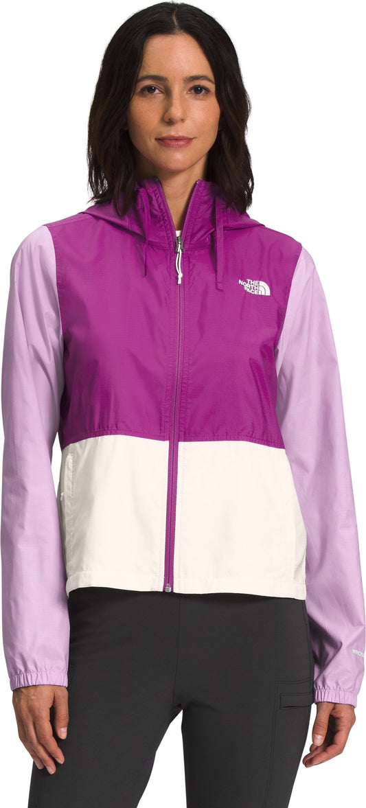 A woman wearing a purple, white, and lavender color block jacket.