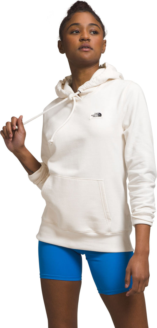 A woman is wearing a white hoodie and blue shorts.