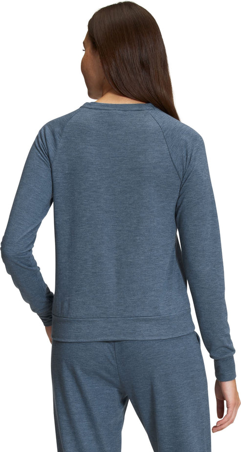 Back view of a woman wearing a blue long-sleeved top.