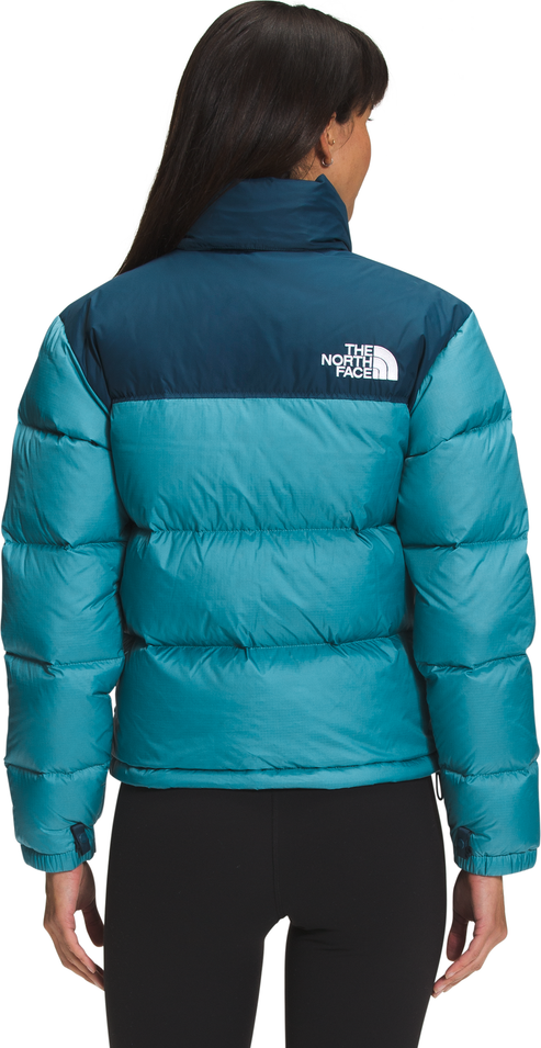 Woman facing away wearing a blue and teal puffer jacket.