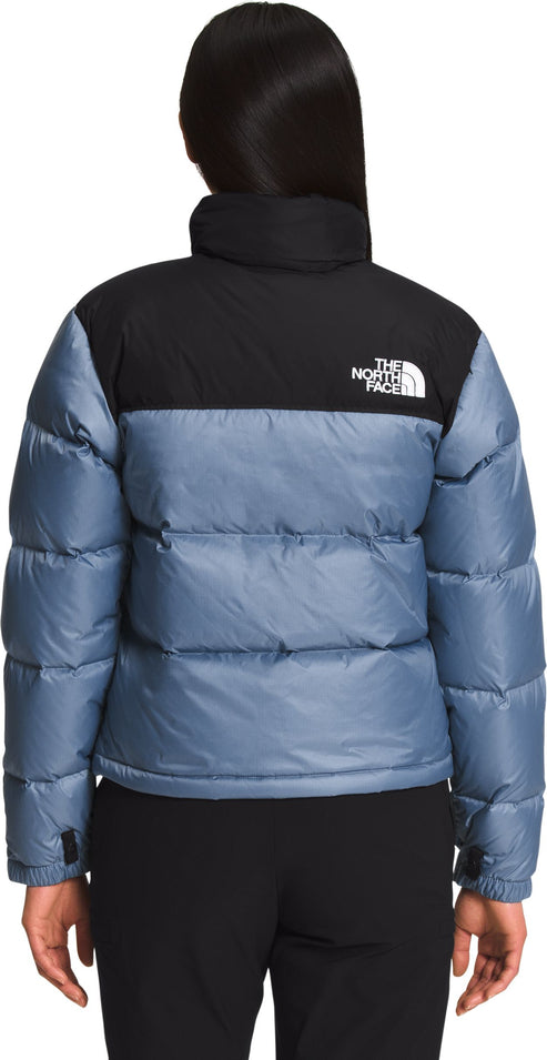 Back view of a two-tone puffer jacket; the top near the collar is black, and the remainder is light blue. The logo is visible on the upper back.