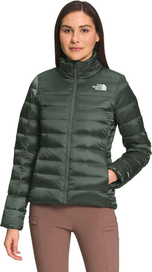 A woman is wearing a light-green, insulated jacket.