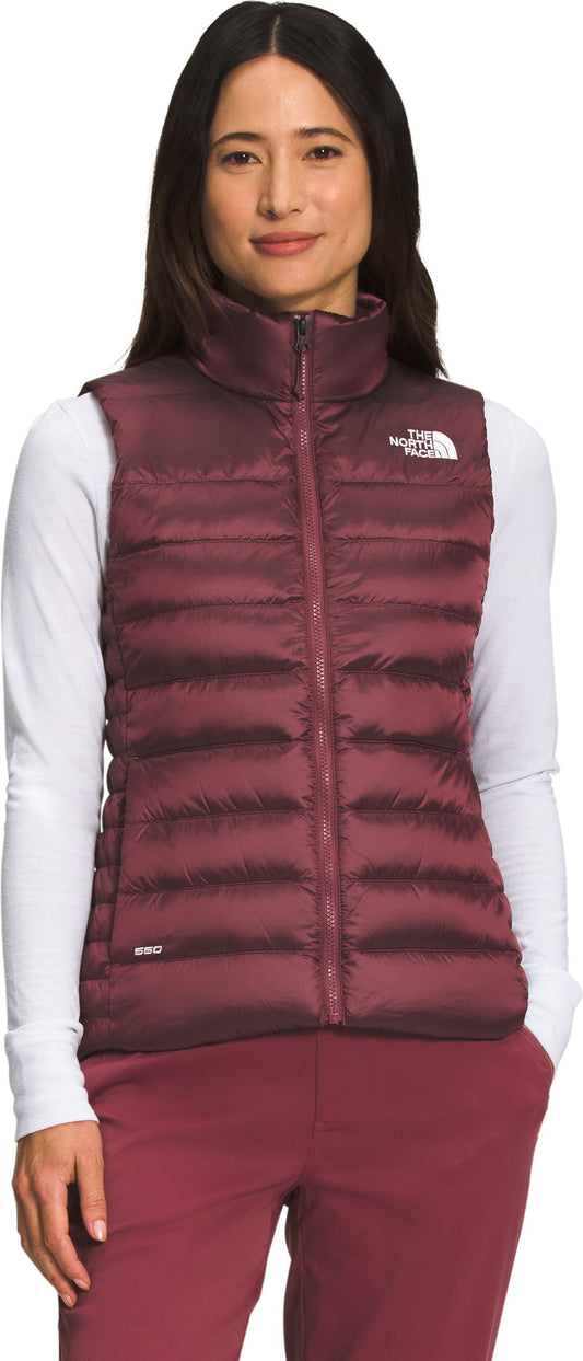 A woman in a maroon vest with a zipper and high collar.
