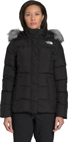 A woman wearing a black puffer jacket with a fur-trimmed hood.