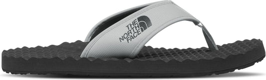 A gray sandal with the logo "THE NORTH FACE" on the strap.