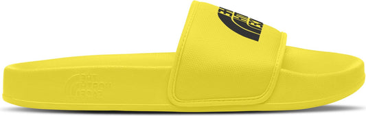 A yellow slide sandal with a black logo on the upper.