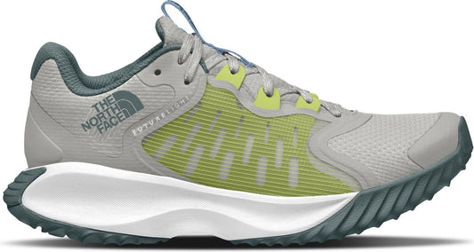 A gray trail running shoe with a green side panel and a white midsole.