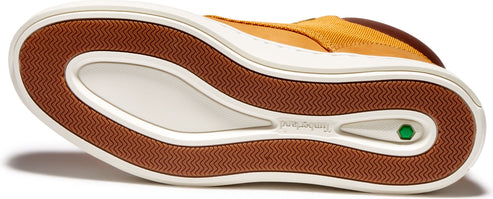 Bottom view of a shoe with a patterned brown sole, white midsole, and visible green logo.