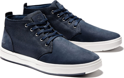 A pair of indigo suede chukka shoes with white soles.