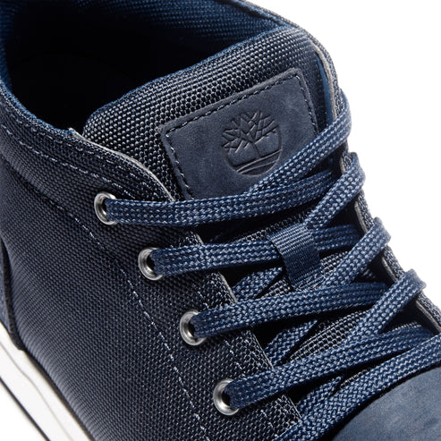 Close-up of a navy blue sneaker with silver eyelets and laces, and a tree logo.