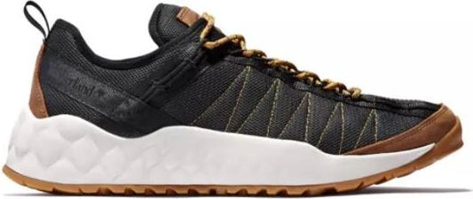 A low-profile sneaker featuring a black upper, brown trim, white midsole, and a brown outsole.