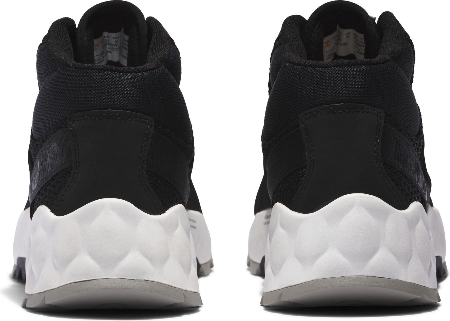 Back view of two black high-top sneakers with white geometric textured soles.