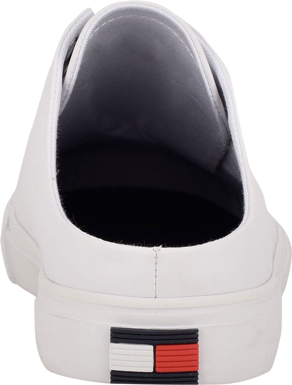 Back view of a white slip-on shoe with a small, rectangular logo of blue, white, and red at the heel.