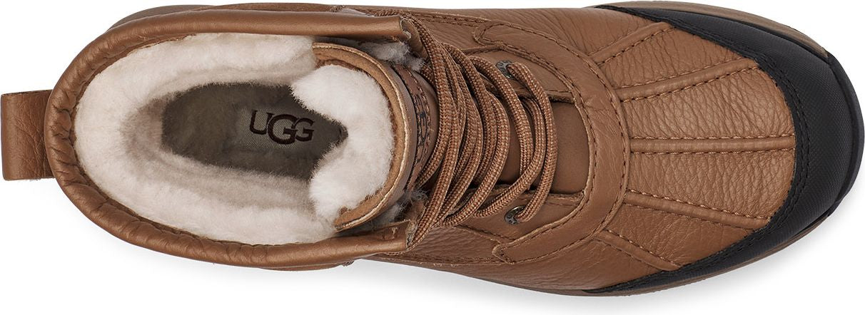 Tan UGG boot with black toe and tan laces, fur lined interior.