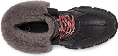 High-angle shot of a black boot with gray faux fur trim and red/black patterned laces.