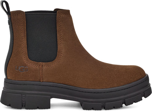 A brown suede chelsea boot with a black elastic panel and a thick black lug sole.