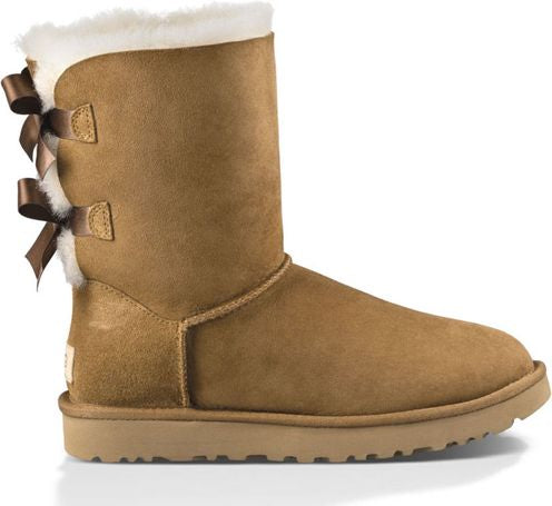 Tan-colored suede boot with sheepskin cuff and decorative satin bow at the back.