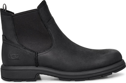 Black leather Chelsea boot with elastic side panels and a lug sole.