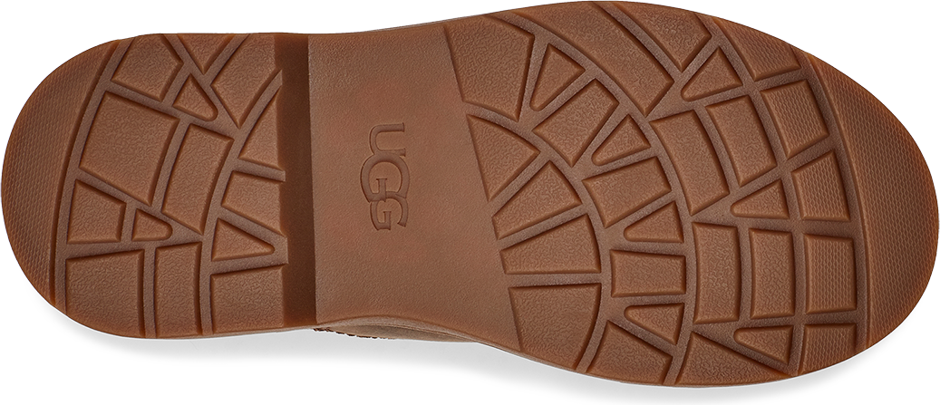 A brown shoe sole with UGG inscribed on it, showing the distinct grid-like tread pattern.