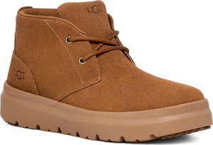 Tan, ankle-high chukka boot with laces and stacked, lugged sole.  'UGG' is visible on the tongue and side.