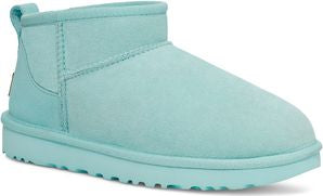 Aqua colored ankle-high suede boot with a flat sole and a fabric loop in the back.
