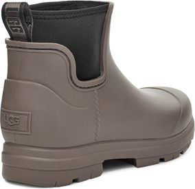 Low-cut taupe boot with a black collar and pull tab on the back.