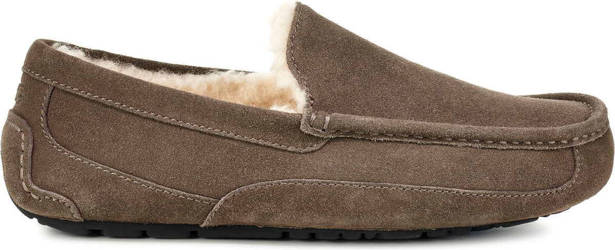 A brown suede loafer-style slipper with faux fur lining.