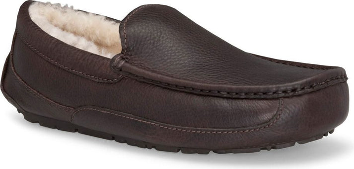 A brown leather loafer slipper with a white, fluffy lining.
