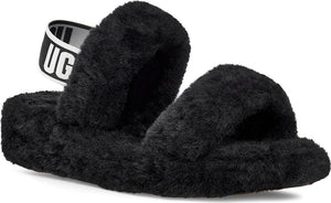 Black, fuzzy slip-on sandal with a white strap reading "UGG".