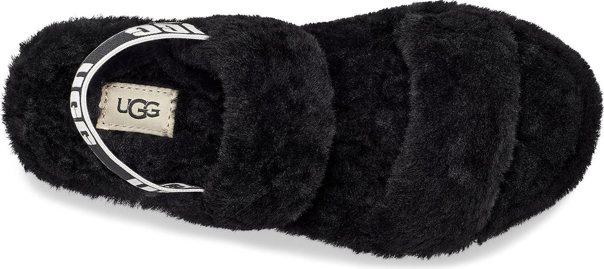 Black furry slide with white strap bearing "UGG".
