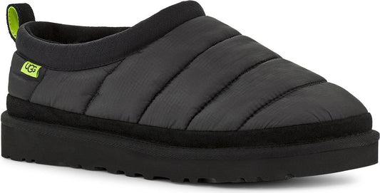 Slip-on puffy, horizontal-stitched, dark gray slipper with a black sole and a loop on the back with a light green accent.