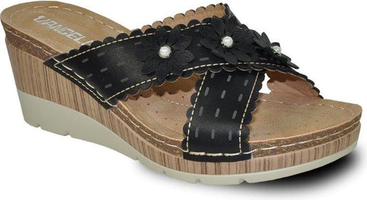 Black wedge heel sandal with scalloped edges, floral embellishments, and faux stitching.