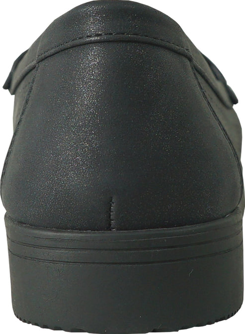 Close-up of a black shoe from the back, showing a low heel and smooth, slightly textured material.