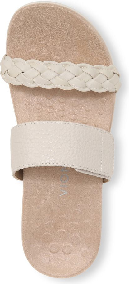 A sandal with a cream braided strap across the top and a cream wide strap further down.