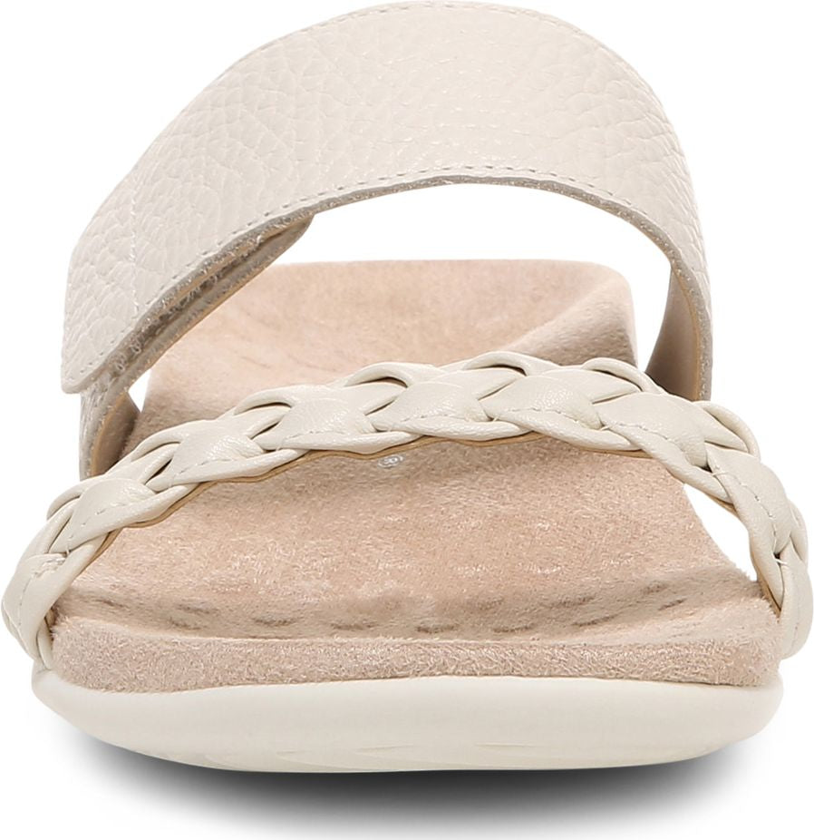 Front view of a flat, cream-colored sandal with a braided strap and an adjustable, buckled top strap.