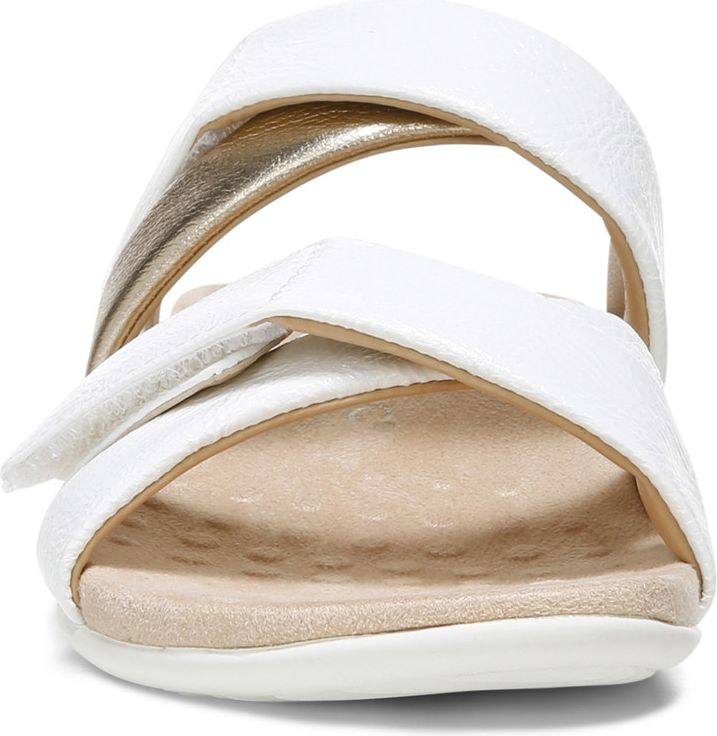 Front view of a white sandal with crisscross straps and gold accents on the inner strap.
