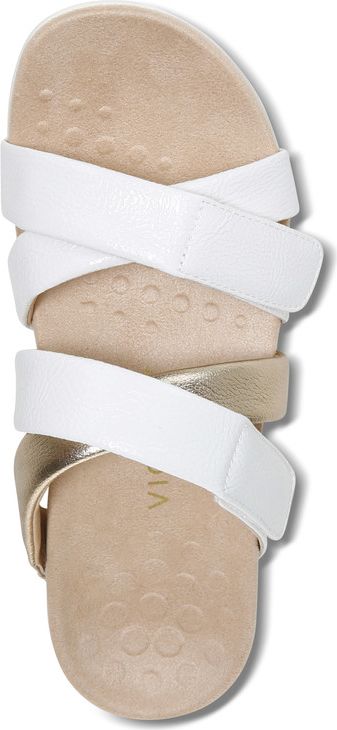 A sandal with white straps crossing over a beige sole.