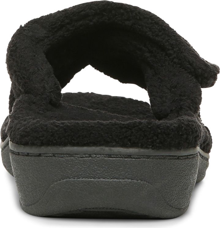 Rear view of a black, fluffy slipper with a slight wedge heel.
