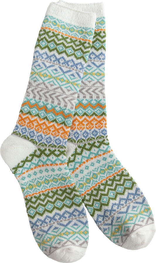 A pair of patterned crew socks with white toes, heels, and cuffs and bands of zigzag, diamond, and geometric patterns in blue, green, orange, and gray hues.
